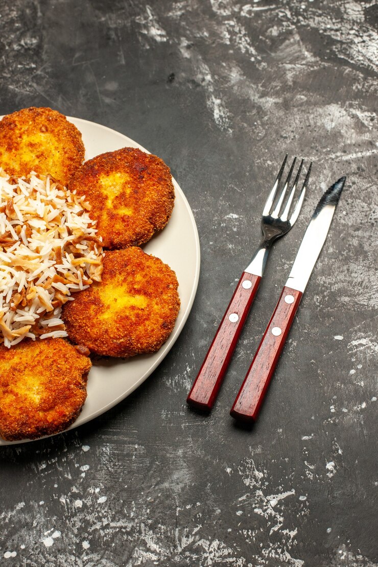 Free Photo top view tasty fried cutlets with cooked rice on dark desk dish meal photo meat