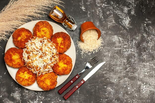 Top view tasty fried cutlets with cooked rice on dark surface dish photo meat