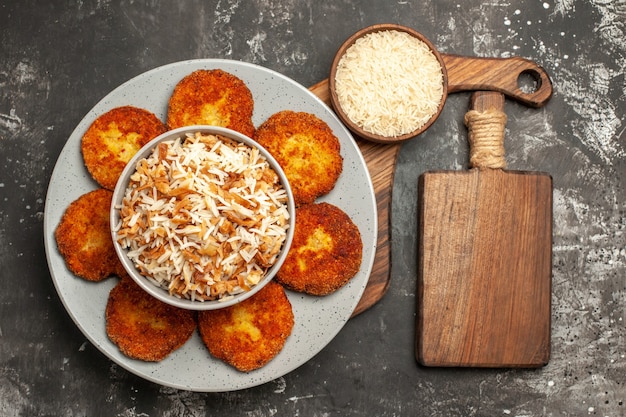 어두운 표면 rissole 접시에 밥과 함께 상위 뷰 맛있는 튀긴 커틀릿