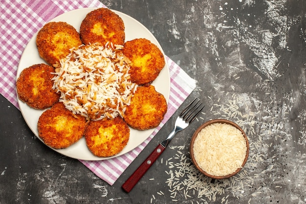 어두운 표면 rissole 고기 요리에 밥을 곁들인 맛있는 튀긴 커틀릿