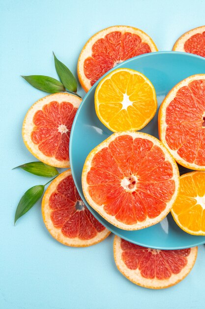 Top view of tasty grapefruits fruit slices on a blue surface