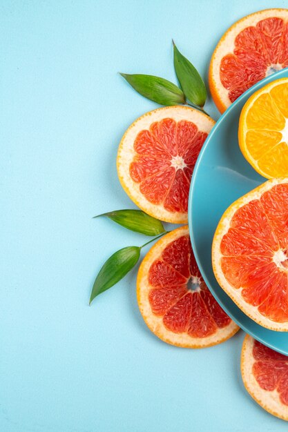 Top view of tasty grapefruits fruit slices on the blue surface