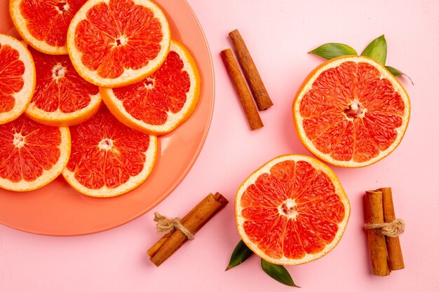 Top view of tasty grapefruits fruit slices on pink surface