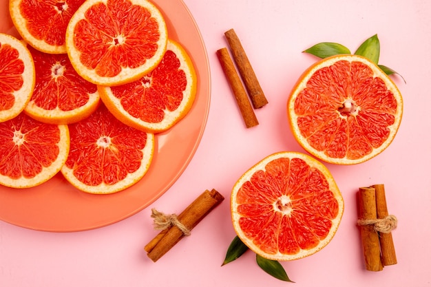 Top view of tasty grapefruits fruit slices on pink surface