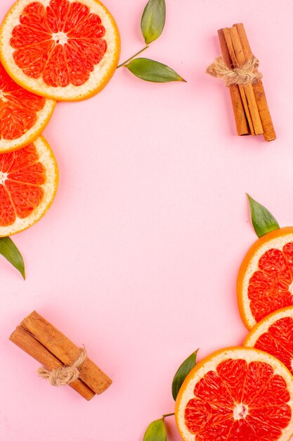 Top view of tasty grapefruits on pink surface