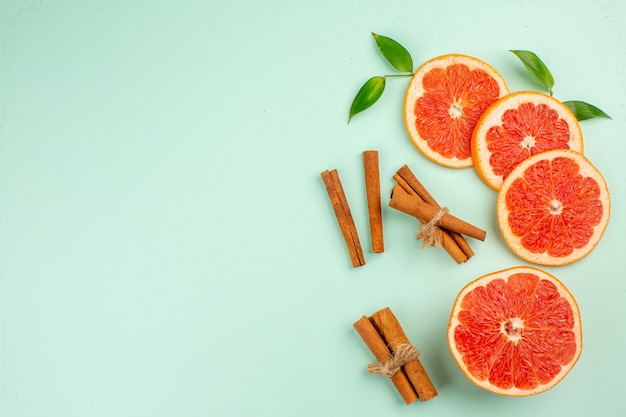 Free photo top view of tasty grapefruits sliced juicy on light-blue surface