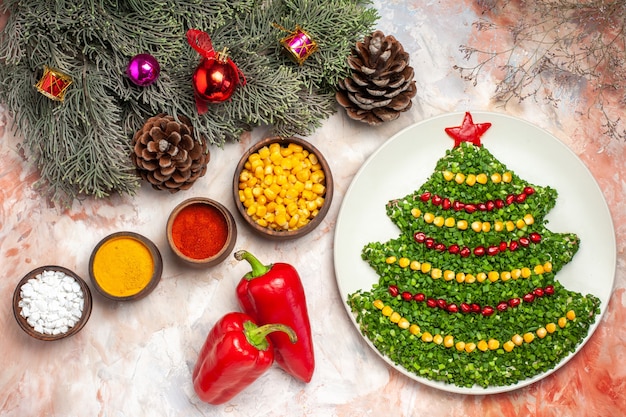 Бесплатное фото Вид сверху вкусный зеленый салат в форме новогодней елки с приправами на светлом фоне