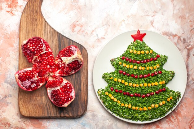 Top view tasty green salad in new year tree shape inside plate on light background