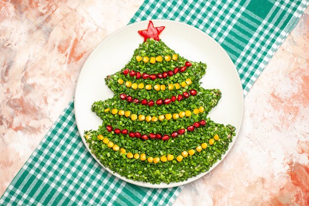 Top view tasty green salad in new year tree shape on light background