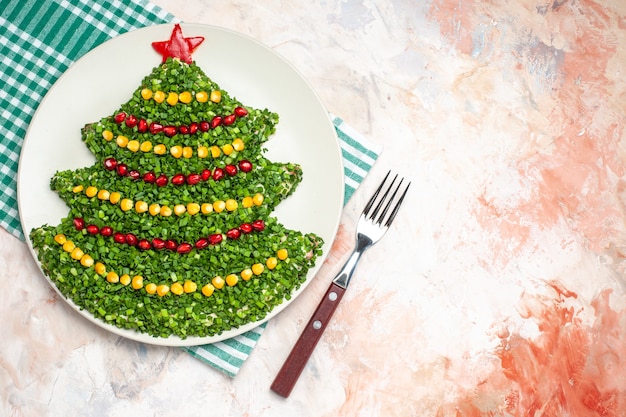 Top view tasty green salad in new year tree shape on light background