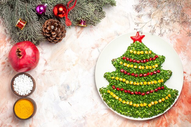 Top view tasty green salad in new year tree shape with seasonings on light background