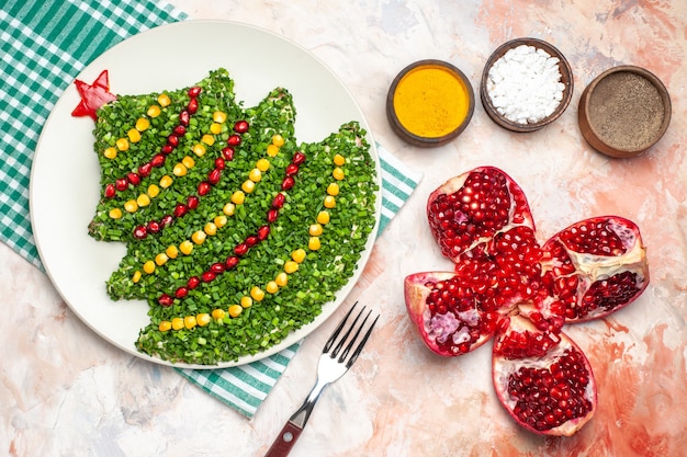 Foto gratuita vista dall'alto gustosa insalata verde a forma di albero di capodanno con condimenti sul pavimento chiaro foto a colori pasto salute vacanza natale