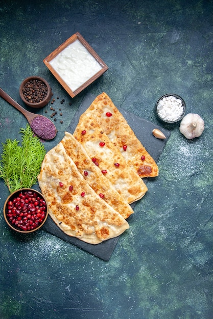 Top view tasty gutabs thin hotcakes with meat and pomegranates on a dark background pastry pie color oven meal dough cake