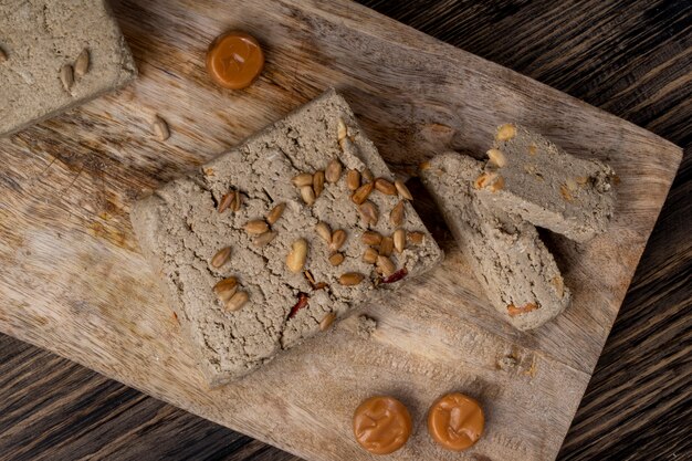 Free photo top view of tasty halva with sunflower seeds on a wooden board