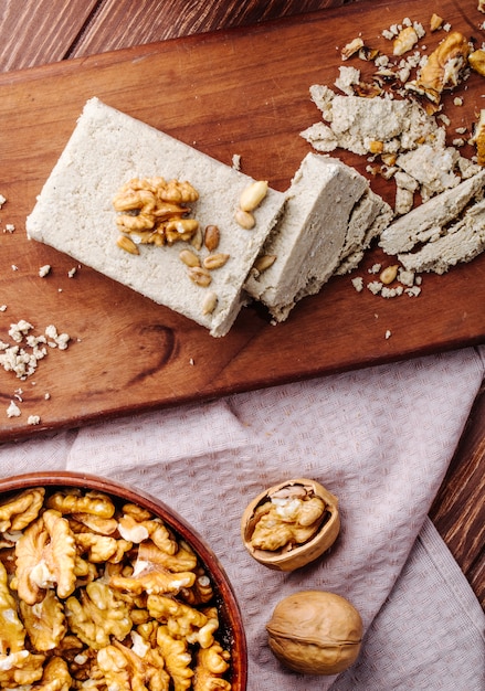 Top view of tasty halva with walnuts on a wooden board