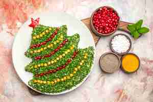 Foto gratuita vista dall'alto gustosa insalata di vacanza a forma di albero di natale sul pavimento chiaro