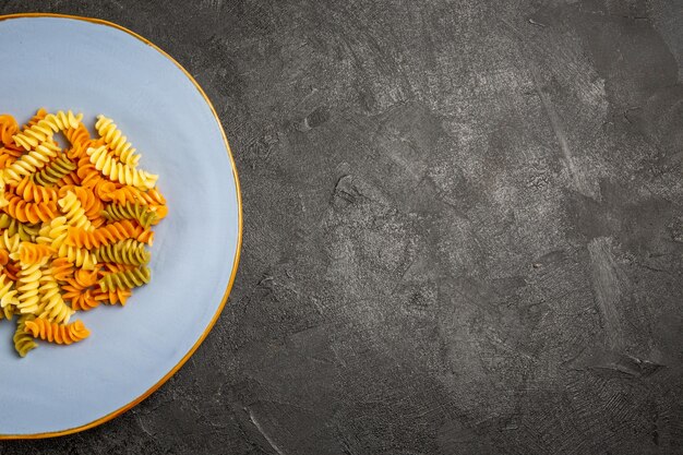 Вид сверху вкусная итальянская паста необычная приготовленная спиральная паста на темноте