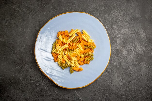 Free photo top view tasty italian pasta unusual cooked spiral pasta on dark