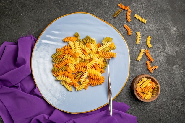 Free photo top view tasty italian pasta unusual cooked spiral pasta on grey