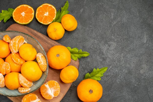 Top view tasty juicy tangerines inside plate on grey background