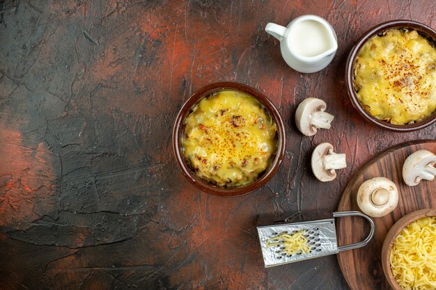 Top view tasty julienne in bowls raw mushrooms milk bowl grater on brown table