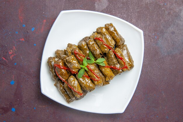 Top view tasty leaf dolma ground meat dish inside plate on dark