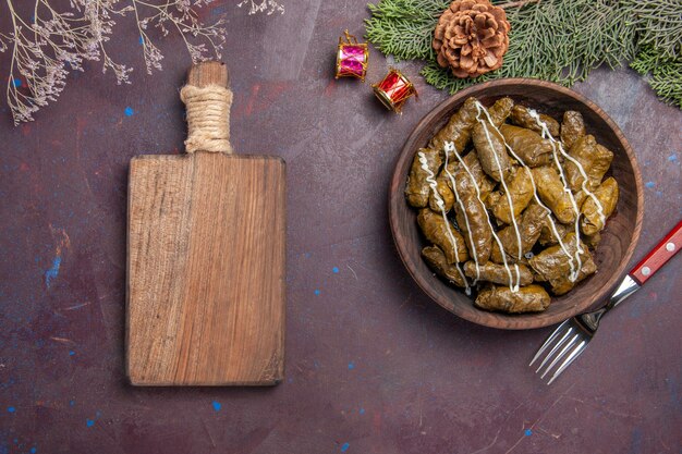 Foto gratuita vista dall'alto gustoso piatto di carne dolma foglia all'interno del piatto marrone su oscurità