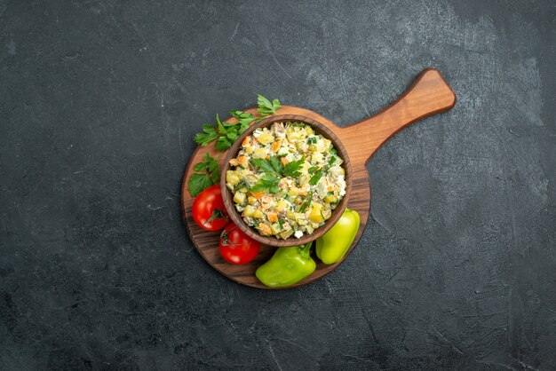 Вид сверху вкусный салат майонез со свежими овощами и зеленью на сером