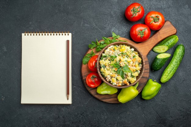 新鮮な野菜と灰色のメモ帳を使ったトップビューのおいしいマヨネーズサラダ