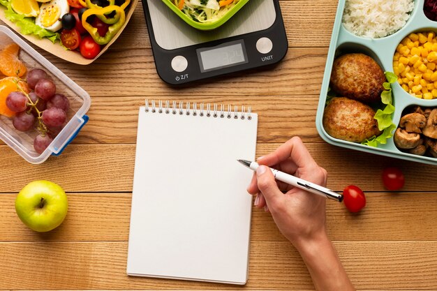 Top view tasty meal arrangement with empty notebook