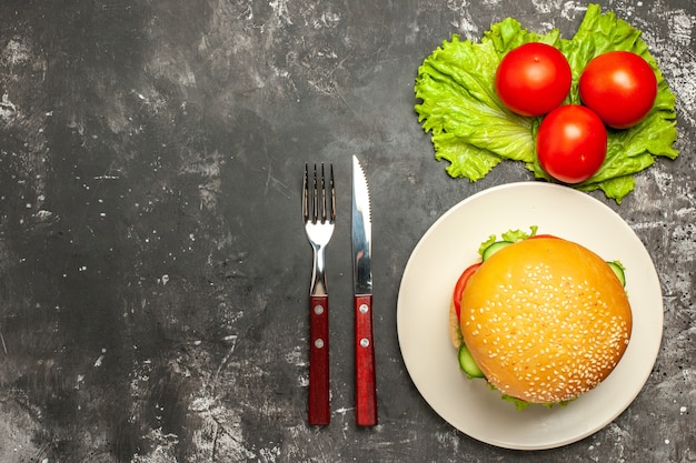 Foto gratuita vista dall'alto gustoso hamburger di carne con verdure su panino panino pavimento scuro fast-food