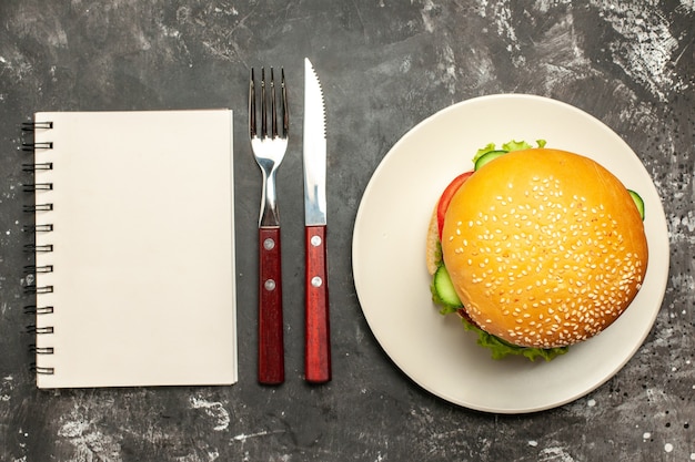 Foto gratuita vista dall'alto gustoso hamburger di carne con verdure sul panino panino superficie scura fast-food