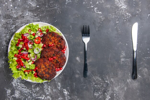 Top view tasty meat cutlets with fresh salad on grey floor photo meat dish food