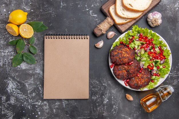 Top View Tasty Meat Cutlets with Salad and Bread on Grey Background