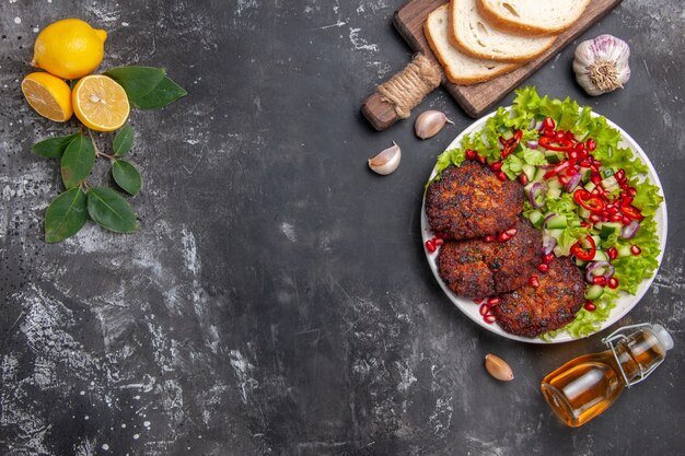 Top view tasty meat cutlets with salad and bread on the grey background dish photo food meal