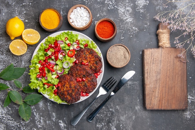 Top view tasty meat cutlets with seasonings on grey background photo food dish