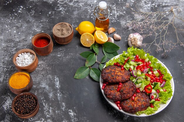 Top view tasty meat cutlets with vegetable salad on grey floor photo food meal dish