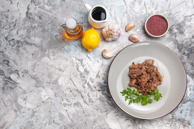 Top view tasty meat dish with sauce and greens on white desk dinner meat dish meal