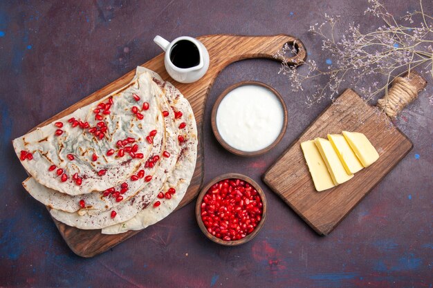 Vista dall'alto qutab di carne saporita pitas con melograni su pita di pasta di carne cibo superficie scura