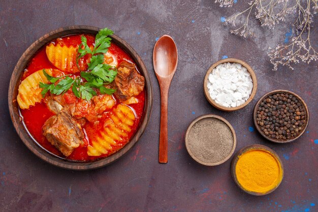 Top view tasty meat sauce soup with different seasonings on black