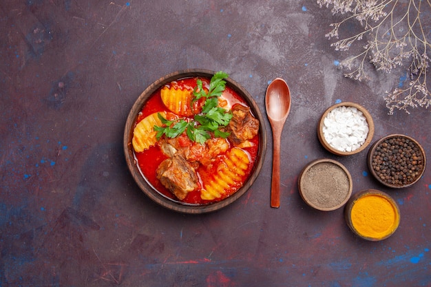 Vista dall'alto gustosa zuppa di ragù di carne con diversi condimenti sul nero