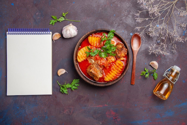 Top view tasty meat sauce soup with greens and sliced potatoes on black