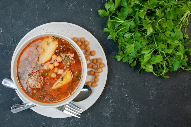 Top view tasty meat soup with beans greens and potatoes on dark background