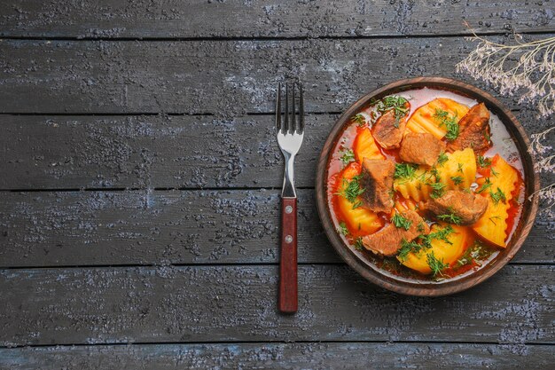 Foto gratuita vista dall'alto gustosa zuppa di carne con verdure e patate sulla scrivania scura