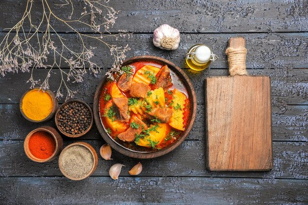 어두운 바닥에 감자와 채소가 들어간 상위 뷰 맛있는 고기 수프