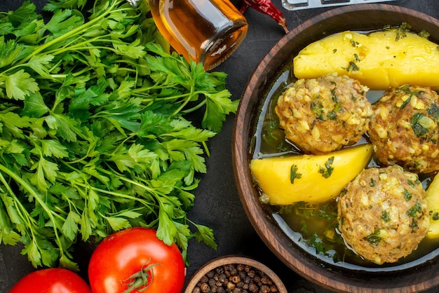 Top view of tasty meatball meal fresh vegetables spikes green pepper on black background