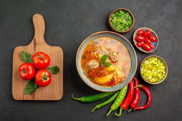 Vista dall'alto gustosa zuppa di polpette di carne con verdure e pepe sul colore piatto salsa di tavola scuro