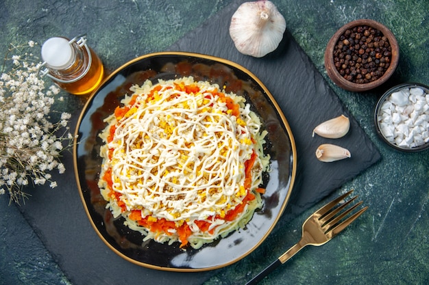 Top view of tasty mimosa salad inside plate on dark blue surface