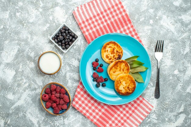 top view of tasty muffins with berries on the light surface