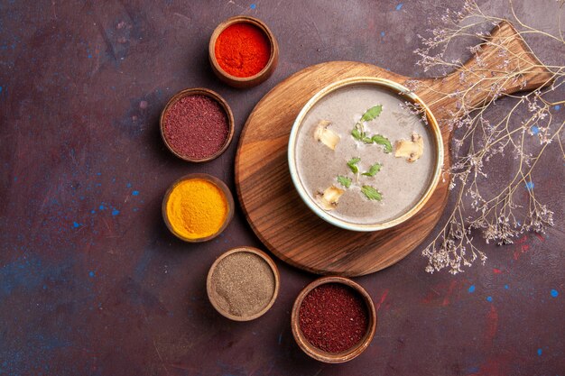 Top view tasty mushroom soup with different seasonings on dark background soup vegetables meal dinner food